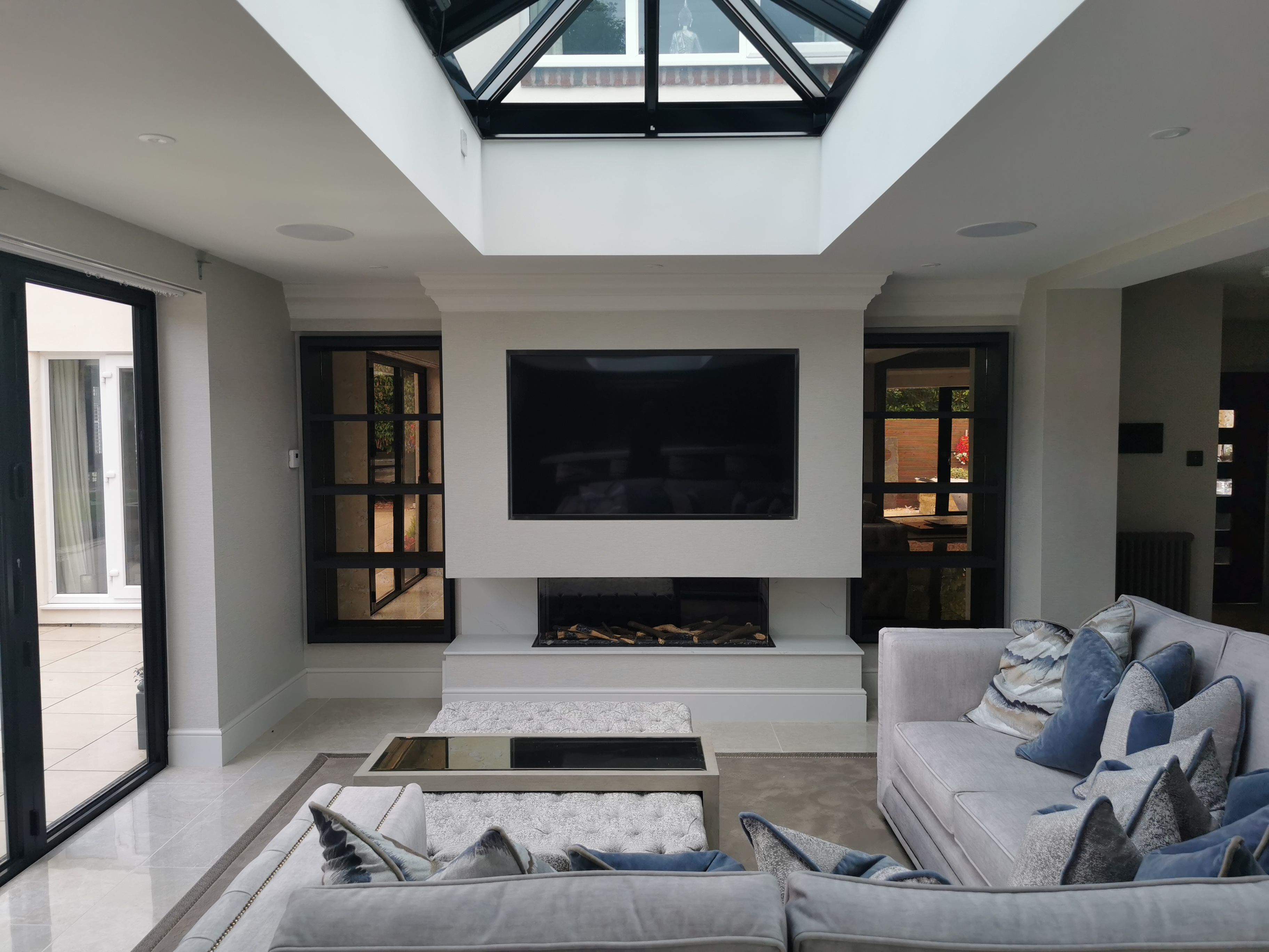 Living Room Media Wall with Fireplace & Skylight